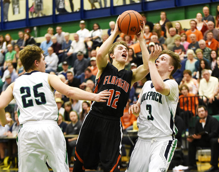 Flathead's Kye AuClaire splits Glacier defenders Jake Norberg (25) and Blayne Bailey (3) as he drives in for a basket during the fourth quarter at Glacier on Friday. (Aaric Bryan/Daily Inter Lake)