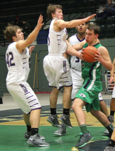 Butte High’s Ryson Lovshin, middle, rises up for a block attempt on Glacier’s John Learn on Tuesday night at the Civic Center. The Bulldogs rolled past the Wolfpack, 60-42, for their first win of the season. Ron Balaskovitz, The Montana Standard