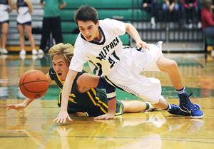 Glacier’s Dylan Ruggles (21) and Whitefish’s Cody Olson dive for a loose ball during the final minutes of a December 20, 2014 basketball game at Glacier High School. (Aaric Bryan/Daily Inter Lake)